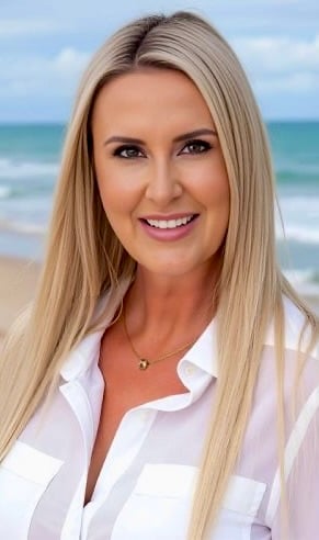 Hervey Bay real estate agent Jasmine Corrick standing in front of of Sold Beachfront Property on the Fraser Coast